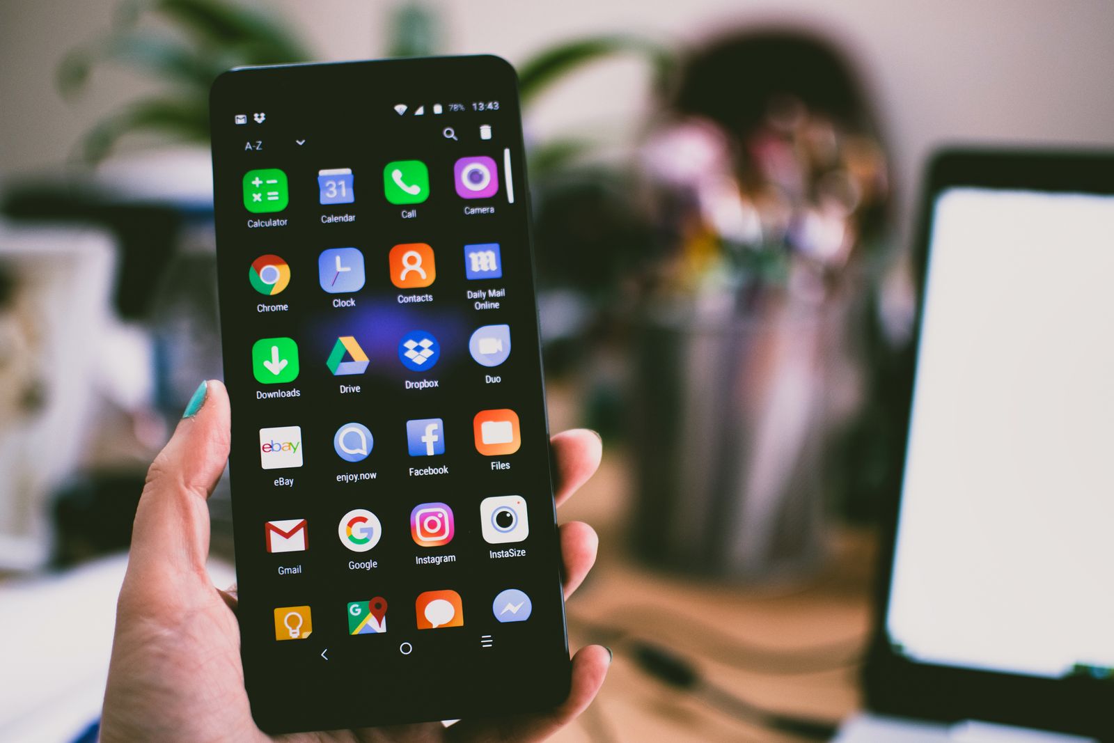 A person holding a phone with Google Maps on the home screen