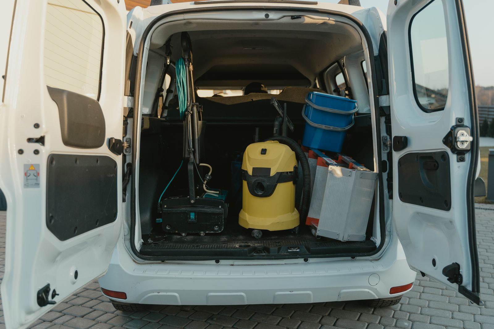 Service van with the back doors open and tools loaded for the day